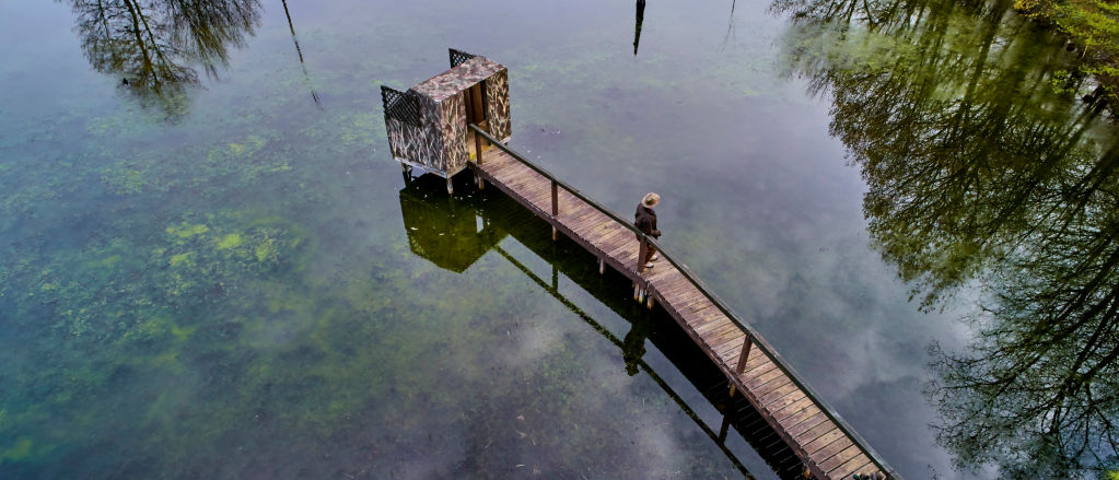 Man stands on dock near duck stand at Orvis Sandanona