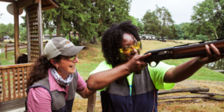 Instructor teaching a woman how to shoot