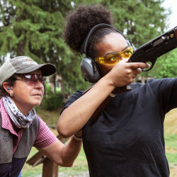 An instructor standing behind a shooter.