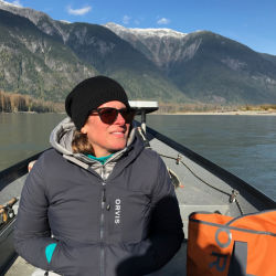 Sandra Rossi sits in a small boat on a mountain lake