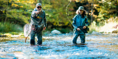 A student and instructor practicing how to cast in a river