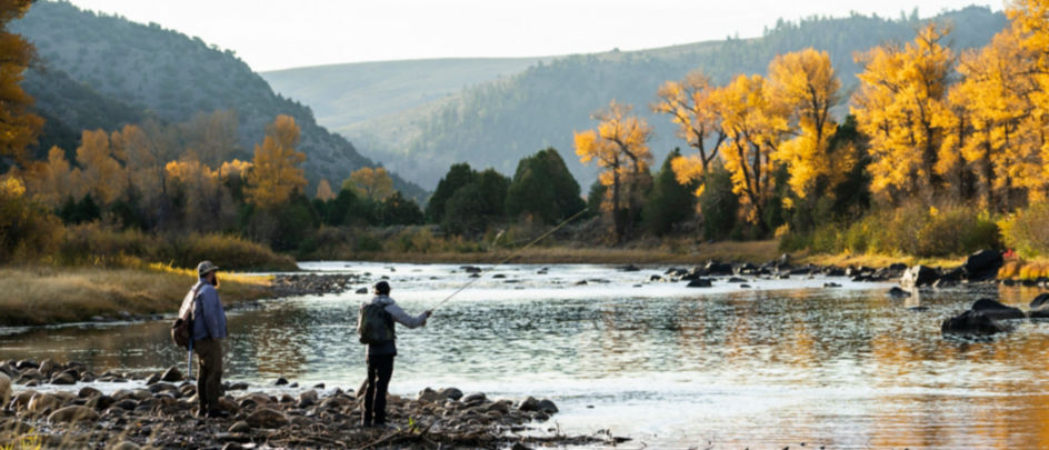 Two anglers casting into a rocky river.