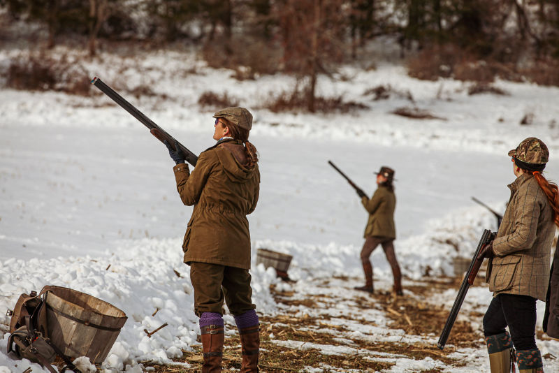 A group of hunters in continental gear stand in the snow.