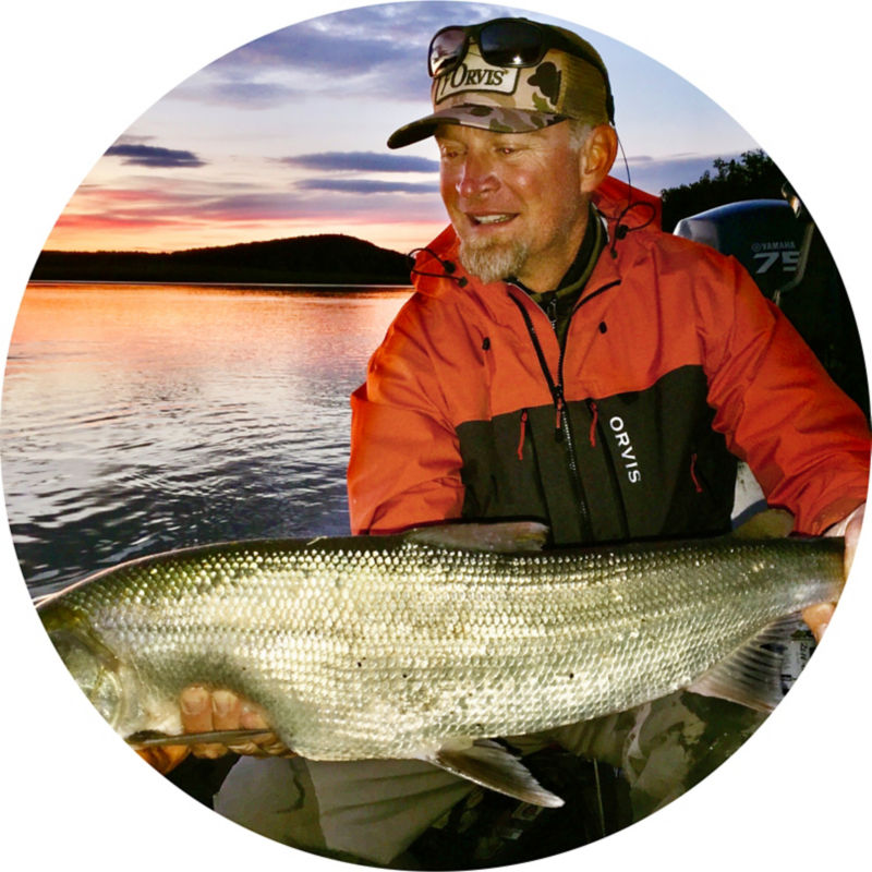Tom Evenson holding a gigantic fish at sunrise.