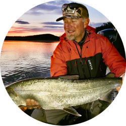 Tom Evenson holding a gigantic fish at sunrise.