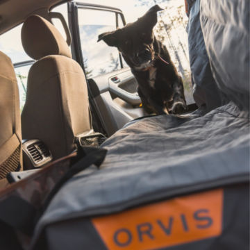 A Dog hops up onto a Tough Trail Seat Protector.