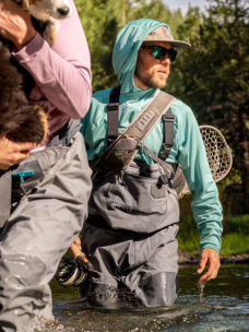 An angler decked-out in PRO gear wades into the river