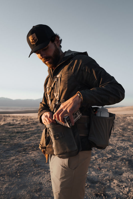 A hunter pauses to retrieve ammunition from his hunting vest.
