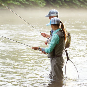 Male and Female Anglers in river prepping clearwater rods.