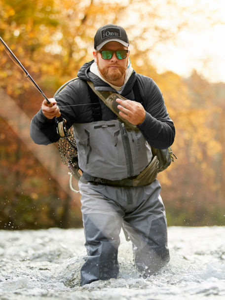 Man shoots line upriver as he wades in Orvis Men's PRO Zippered Waders.
