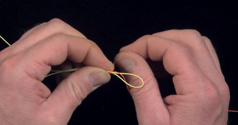 A close-up of fingers tying a knot.