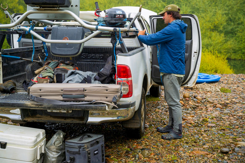 An angler ties together boat geat in the back of their truck.