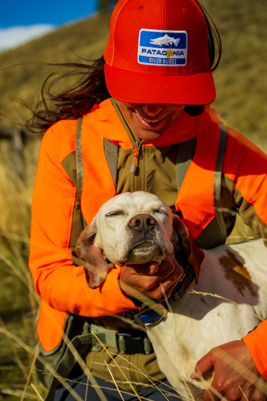 An upland hunter in the field with her dog.