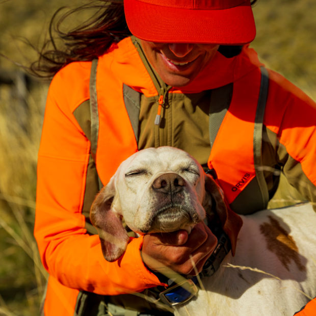 An upland hunter in the field with her dog.