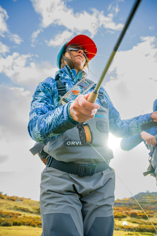An angler sets up her gear before going out into the river.