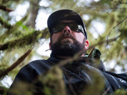 An angler wearing sunglasses among the trees