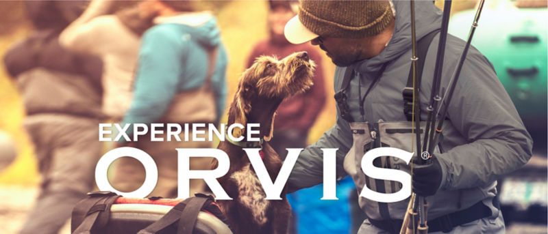 The words "Experience Orvis" superimposed over a man wearing fishing gear nose to nose with a scruffy brown dog.
