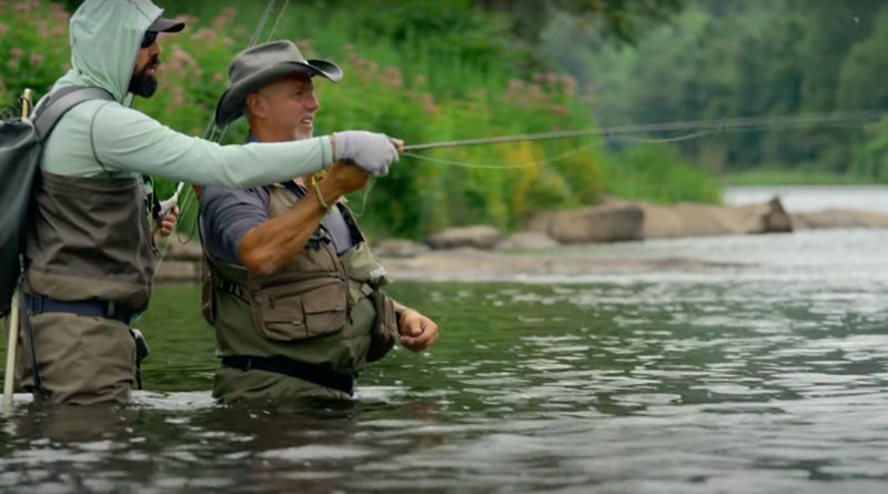 An instructor teaching a student how to cast in the water