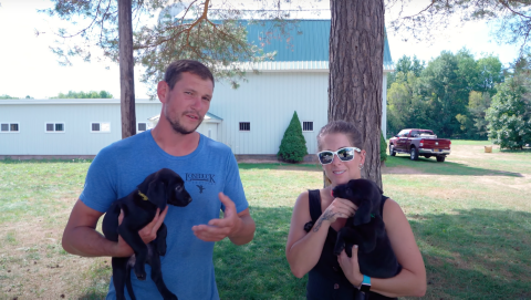 Ethan & Kat Pippitt both holding black lab puppies