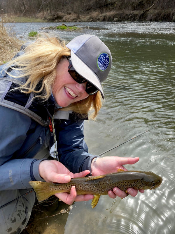 Smiling woman holding a brown trout