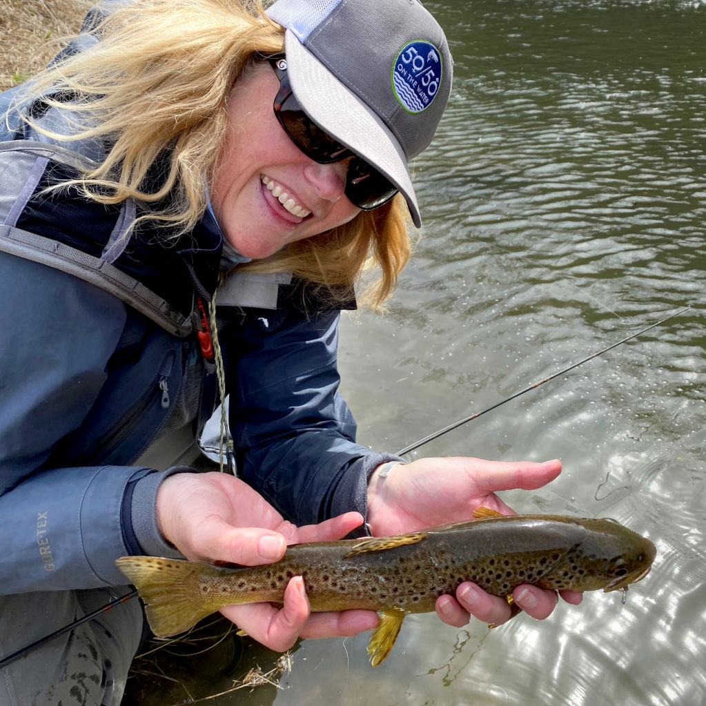 Smiling woman holding a brown trout