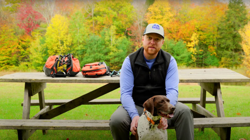 A man sitting at a picnic table with a dog