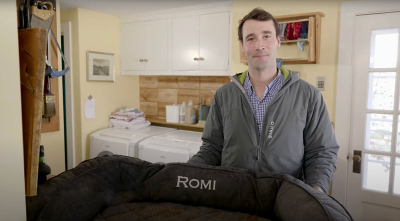 Charley Perkins standing in a laundry room showing how to wash a dog bed.