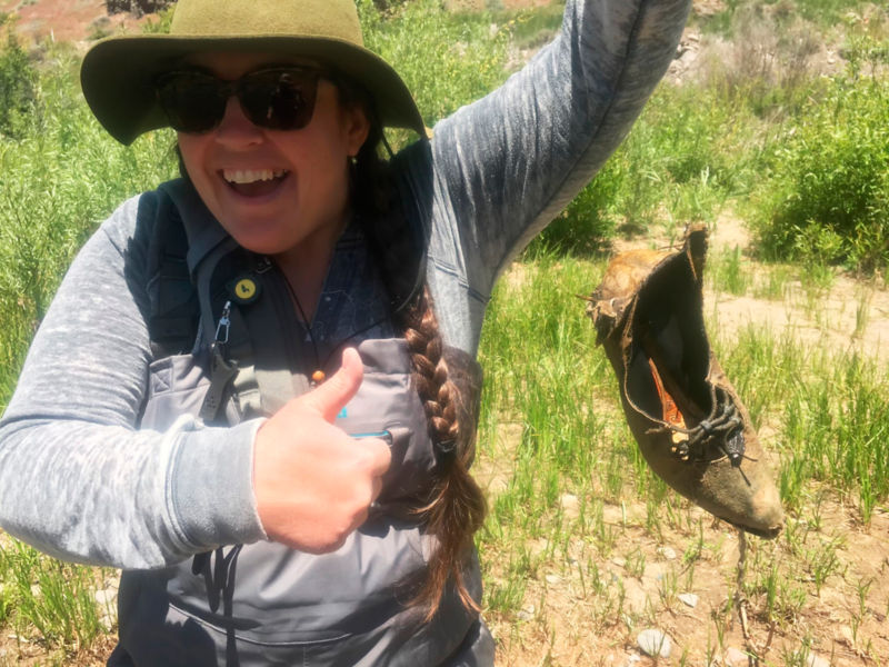 Kasey holding up a moldy shoe that she caught while fishing (like a fishing trophy)