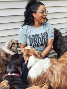 Melinda wearing a grey shirt surrounded by dogs