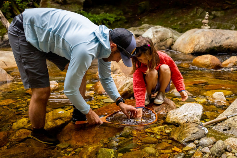 Simon Perkins and his daughter release a fish back into a stream