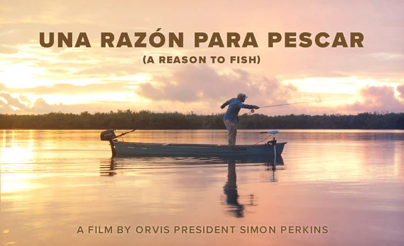 An angler casts a fly rod from a small motorboat silhouetted against a glorious peach and gold sunrise.