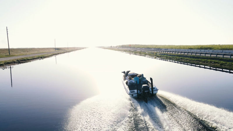 A boat plies a straight stretch of water