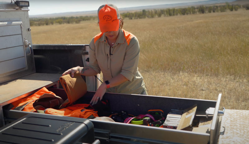 A woman waring hunting gear going over what she pack.ed in her slide out draw for hunting