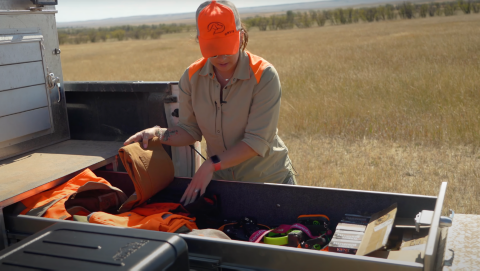 A woman waring hunting gear going over what she packed in her slide out draw for hunting